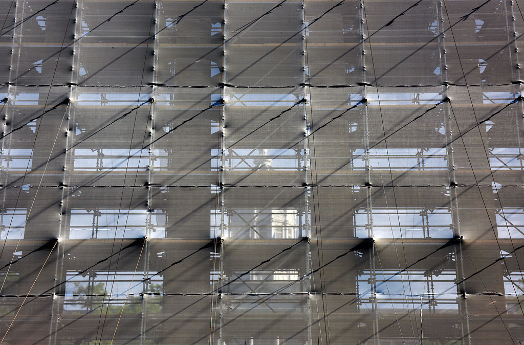 A construction barrier shrouds the historic columns